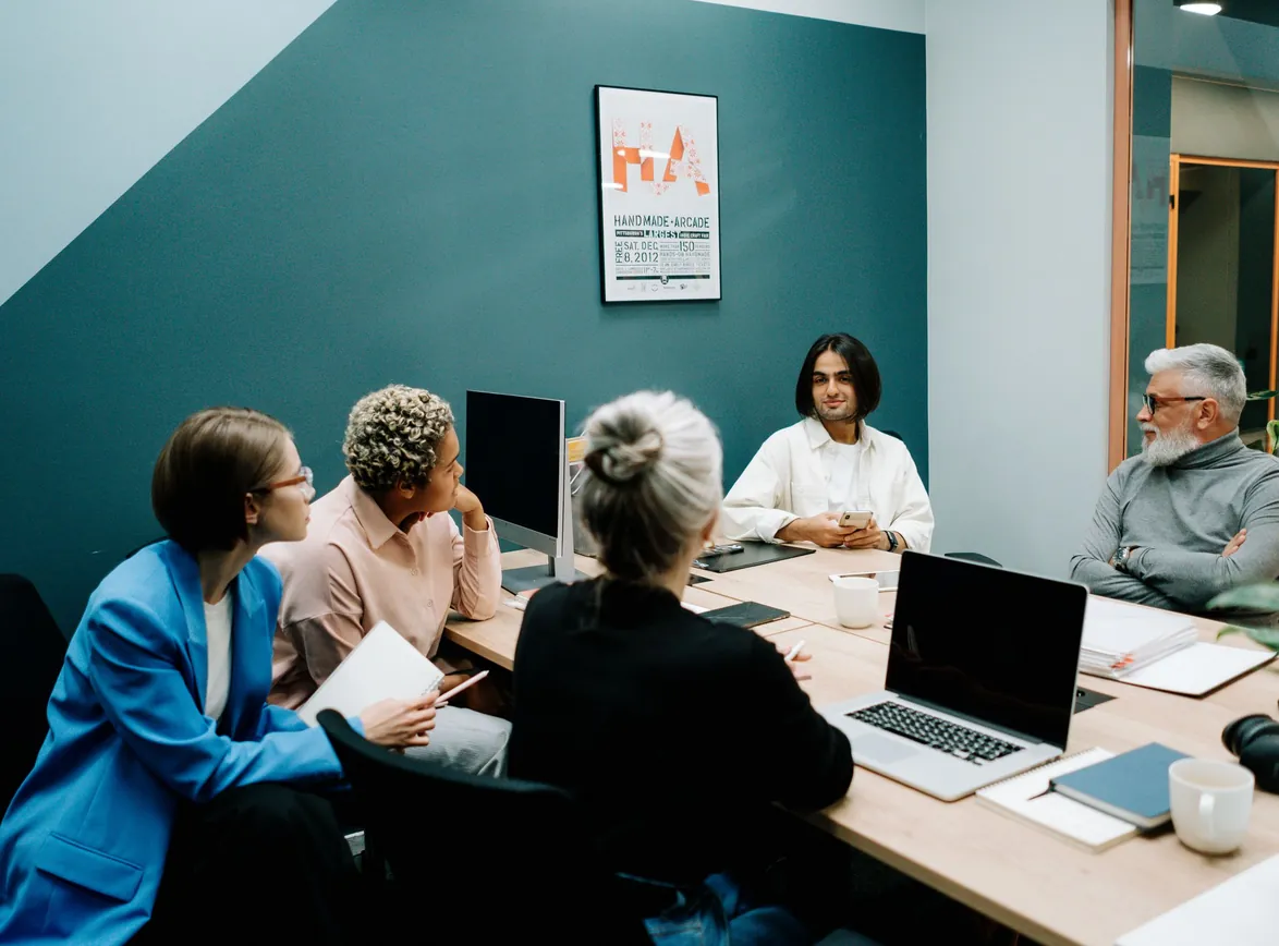 A group of professionals engaged in a dynamic meeting in a modern office environment