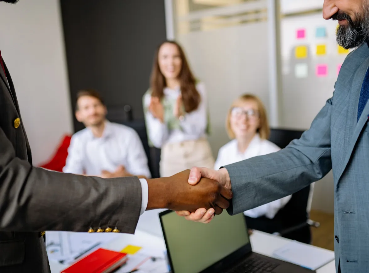 Close-up of a handshake between colleagues in a professional office setting