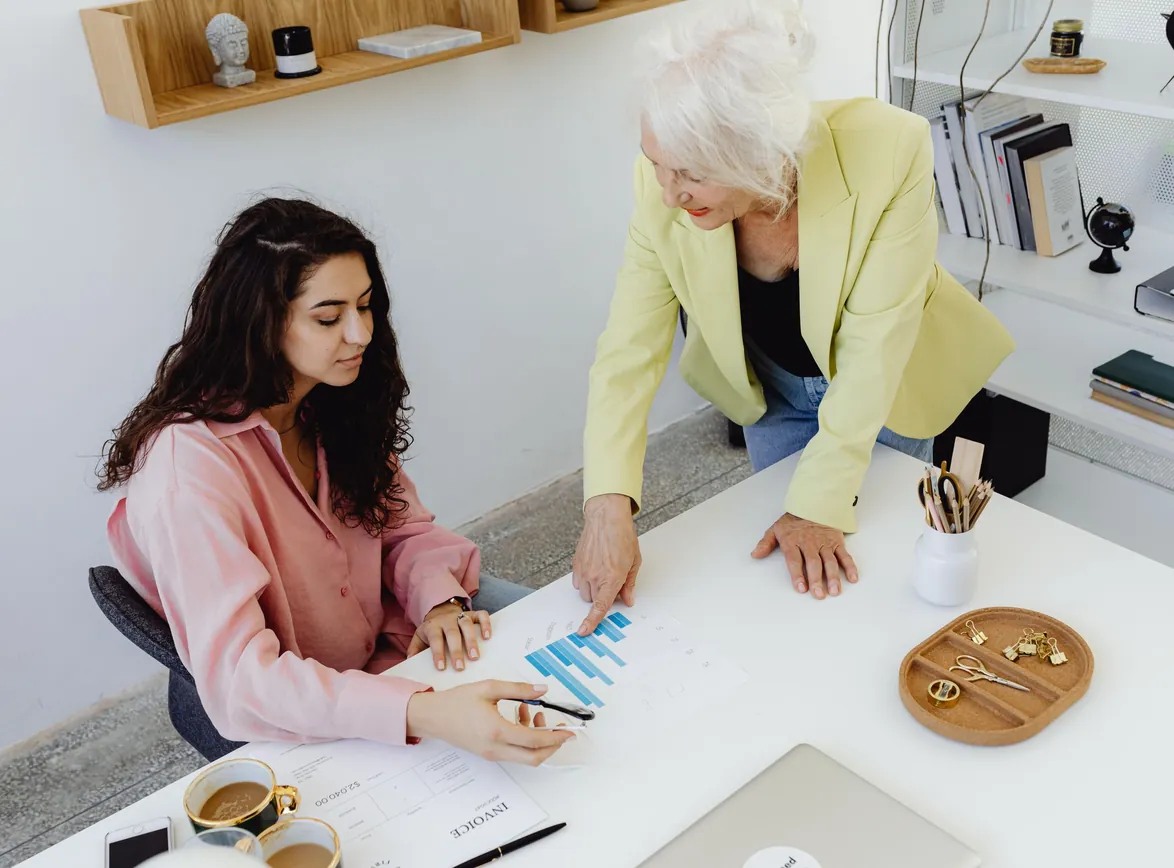 Two women analyzing business data in a modern office setting