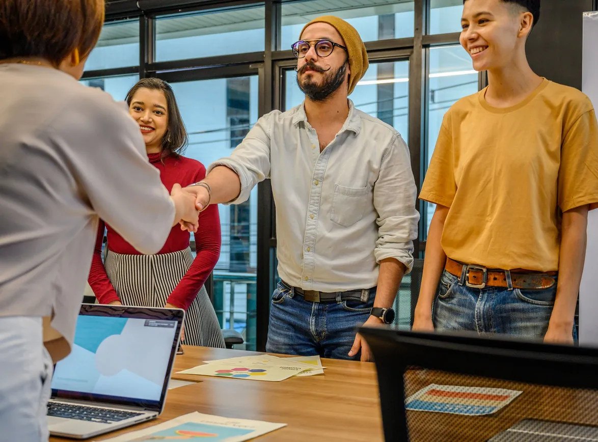 Colleagues shaking hands during a business meeting in a modern office setting