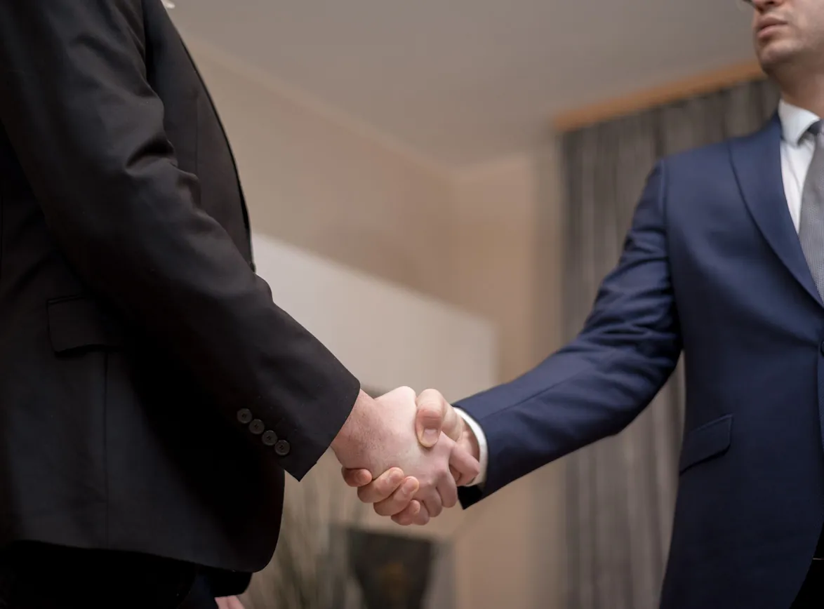 Two businessmen in suits shaking hands