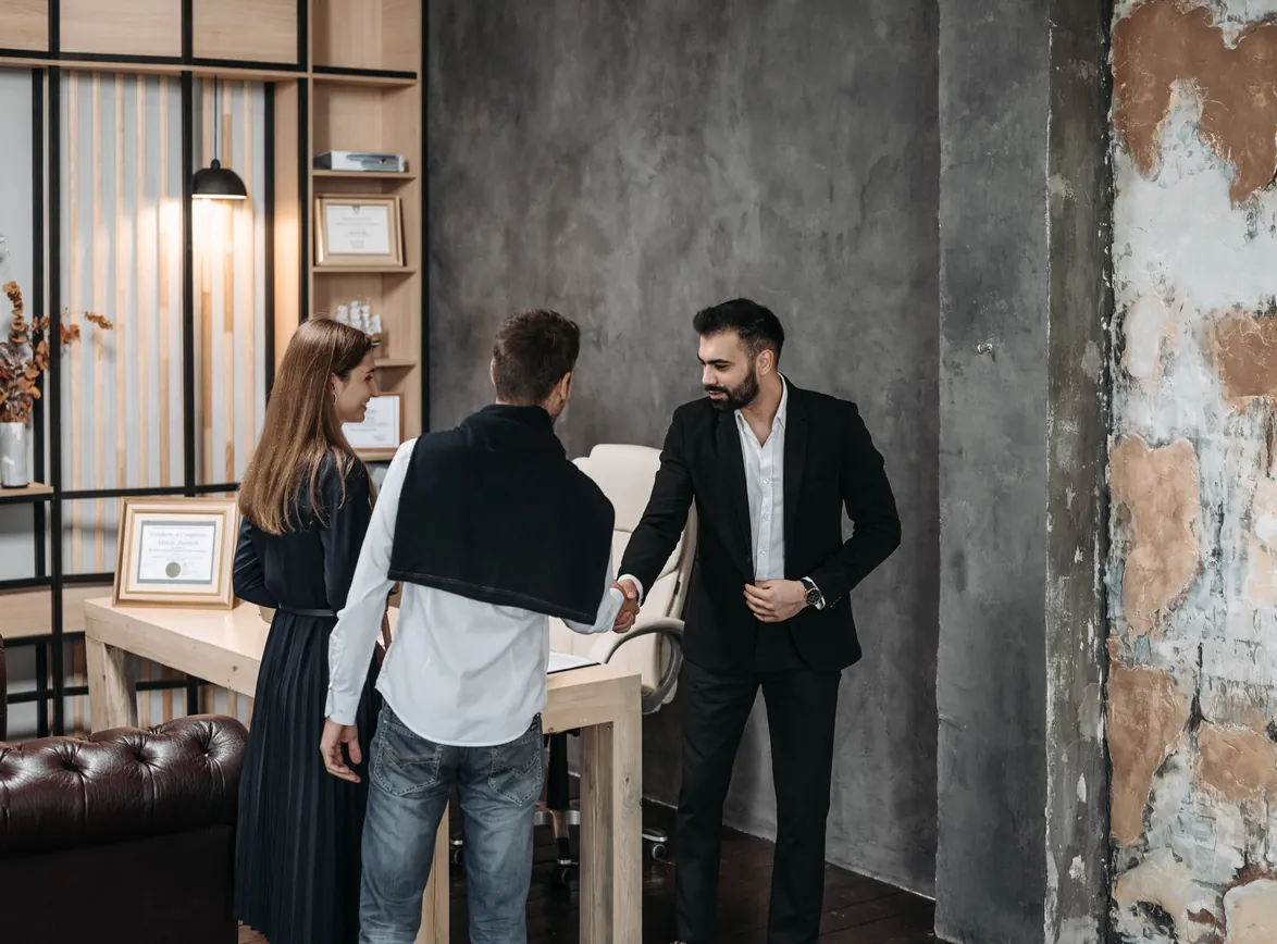 Business professionals discussing in a modern office setting with a handshake agreement