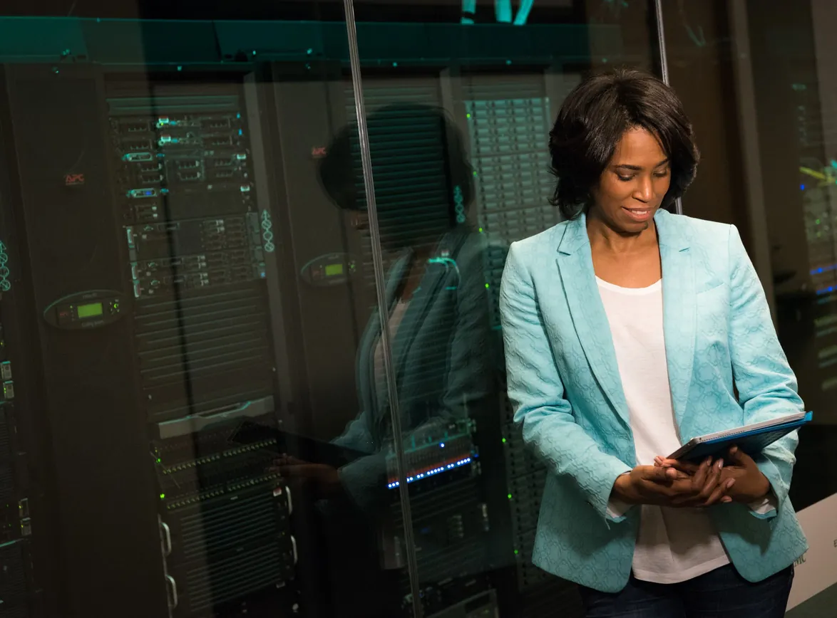 Female IT professional examining data servers in a modern data center setting