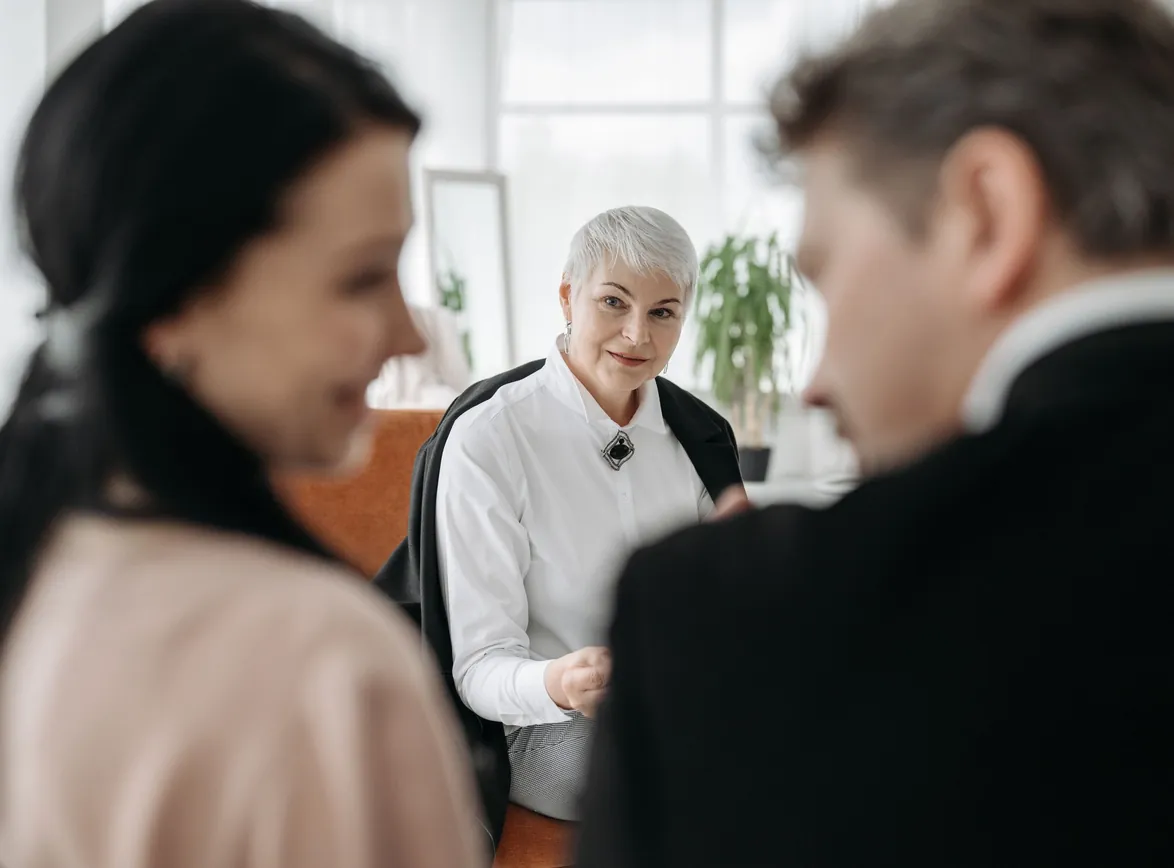 A professional consultation session with two clients and an advisor in a modern office environment