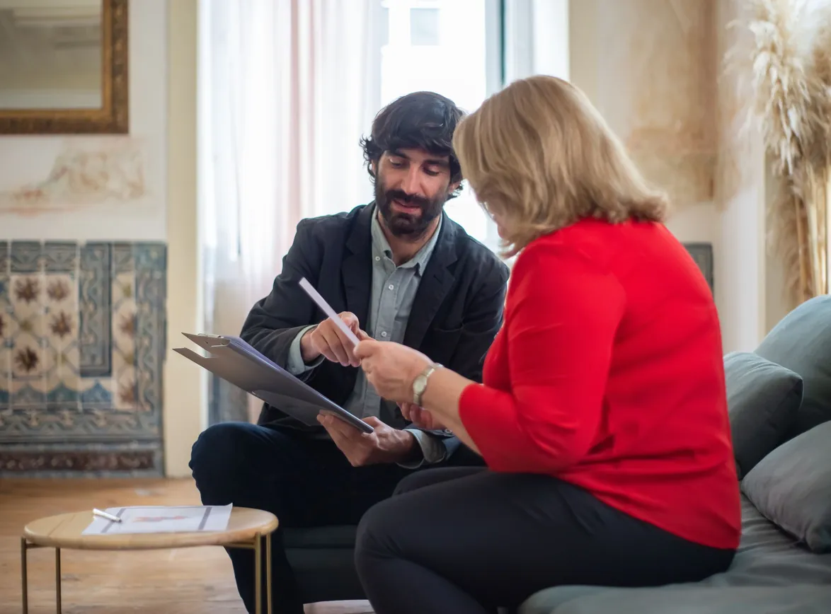 A man and woman having a business discussion seated on a sofa in a stylish room