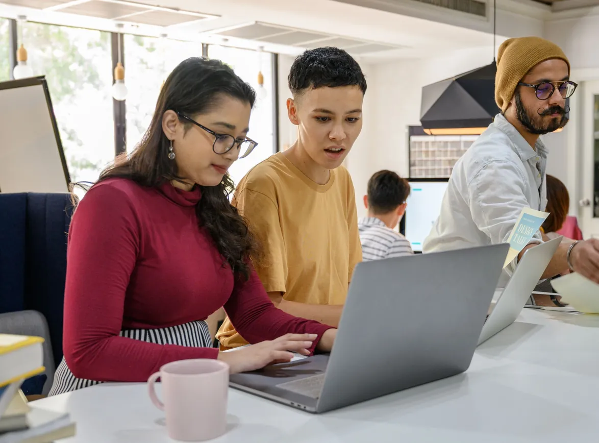 A group of coworkers engaged in a brainstorming session at a modern office workspace