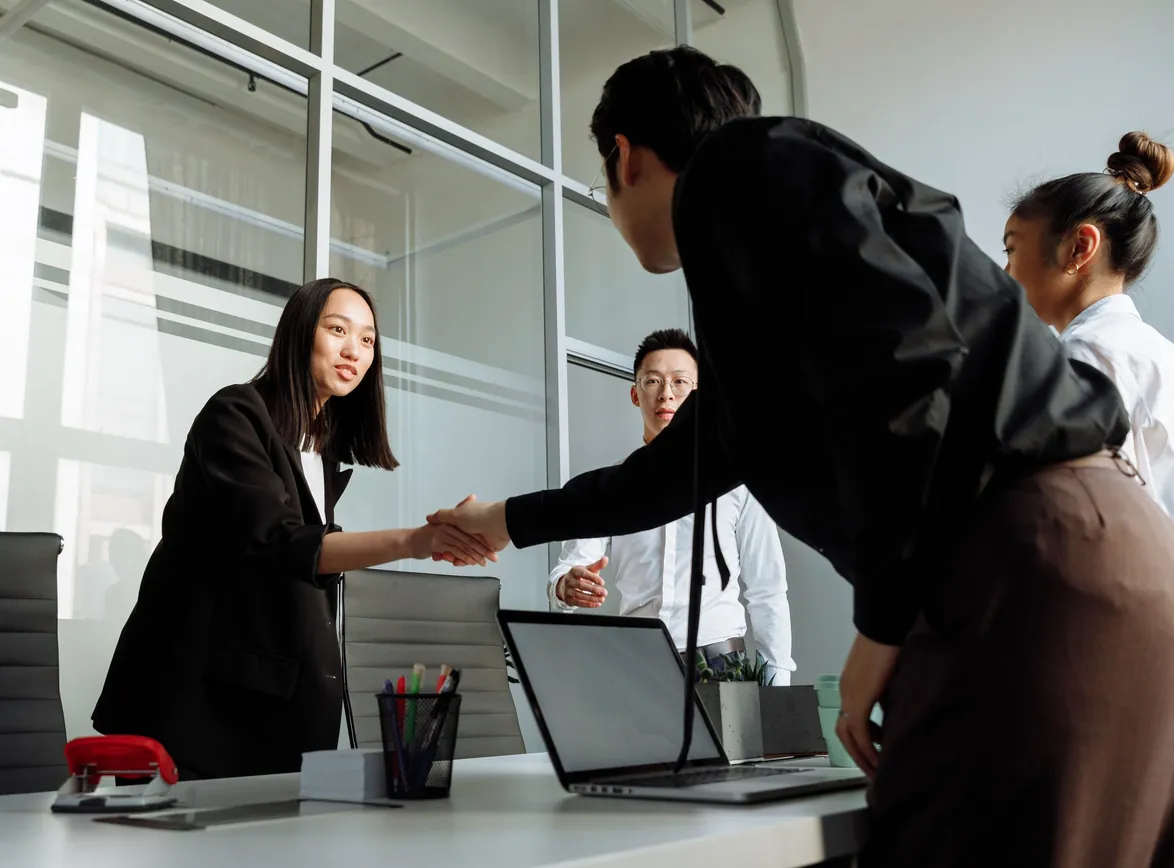 Group of business colleagues shaking hands during an office meeting