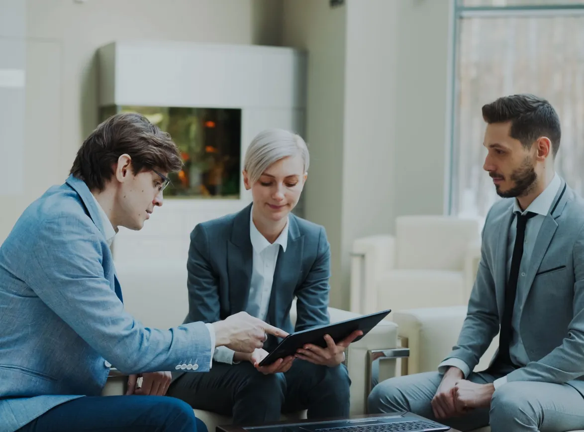 Three professionals engaging in a business meeting in a modern office setting