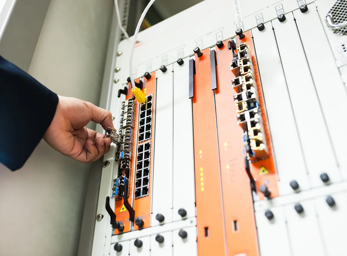 Close-up of a hand adjusting network equipment in a data center