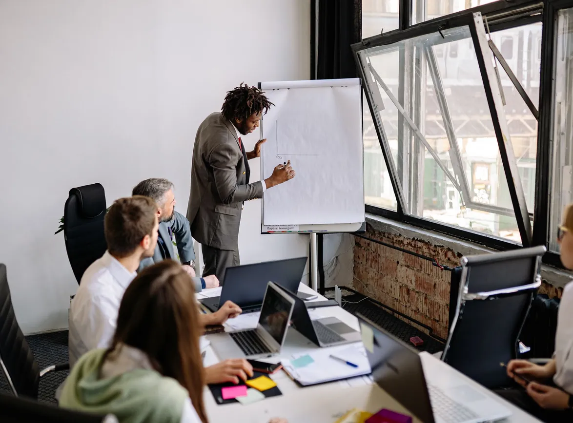 Team engaged in a business meeting with a presentation in a modern office setting