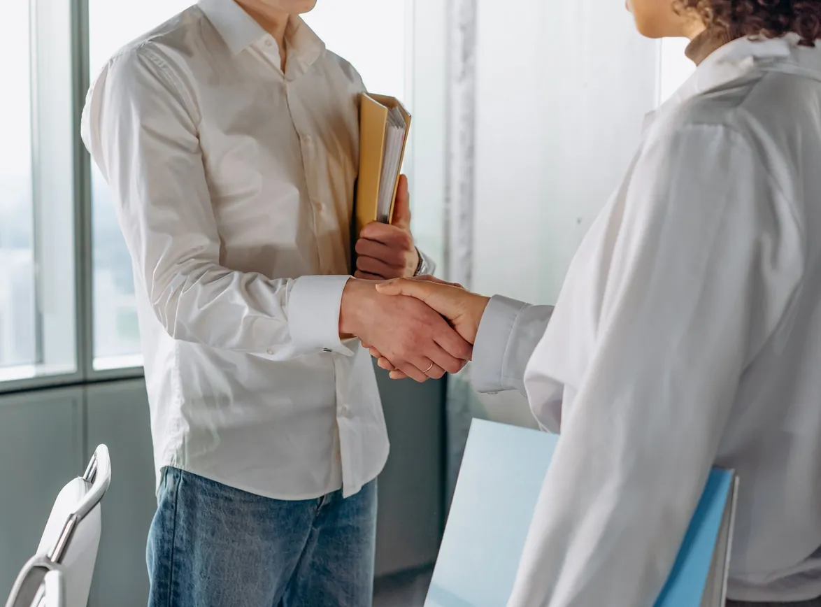 Two professionals shake hands indoors