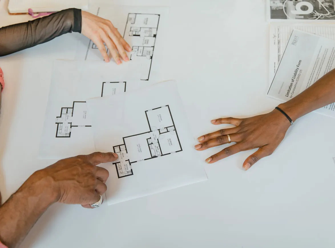 Overhead view of team planning business strategy with floor plans