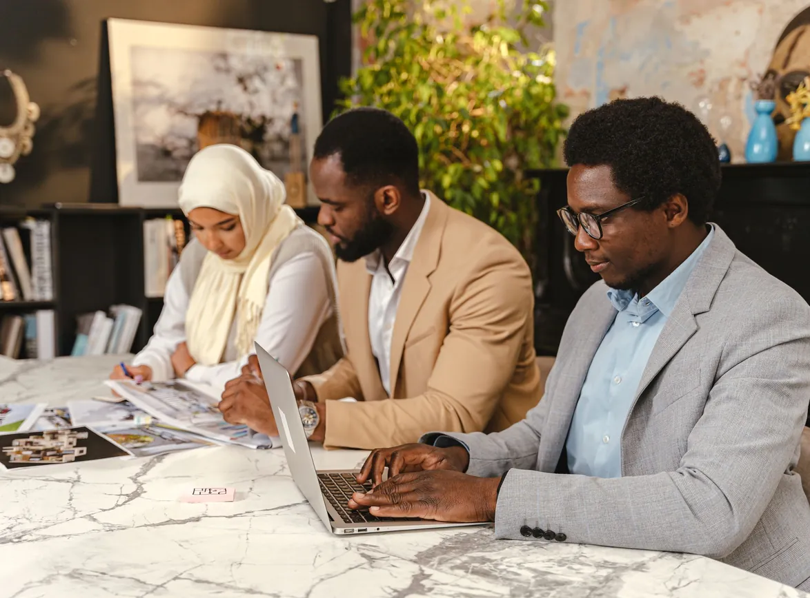 A team discusses ideas at a marble table, brainstorming and planning in an office setting
