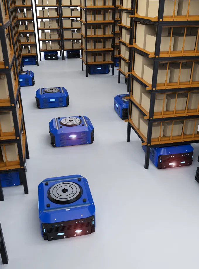 Autonomous mobile robots moving between storage racks stacked with boxes in a warehouse